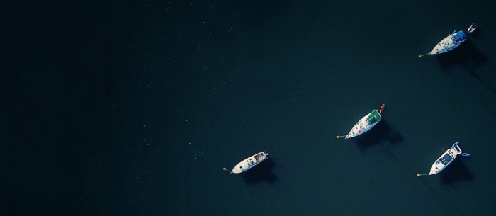 Four boats floating in the water