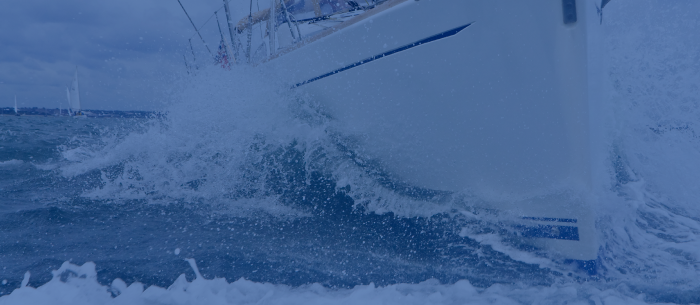 Front of a yacht crashing into a wave