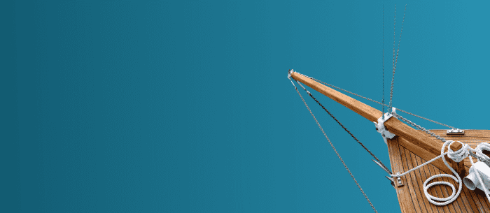 Wooden bow of boat with light blue background